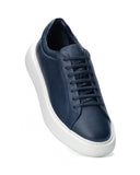 A navy blue leather low-top sneaker with matching navy laces and a thick, chunky white platform sole, shown from a three-quarters angle on a white background.