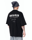 "Slogan" Men’s Oversized Printed Designer T-shirt in Black paired with loose light blue denim jeans