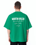 "Slogan" Men’s Oversized Printed Designer T-shirt in Green styled with black relaxed-fit trousers and white sneakers