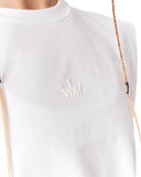 Close-up of a white crewneck t-shirt featuring a small white embroidered crown logo on the chest, worn by a model with a braided blonde ponytail visible on the right side.