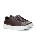 Pair of navy blue sneakers with white soles on a white background