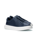 A pair of navy blue leather low-top sneakers with matching navy laces and thick white platform soles, shown from a three-quarters angle on a white background.