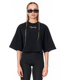 A model wearing a black cropped t-shirt with a white 'Martin Valen' logo on the chest, paired with black leggings and black sunglasses, against a plain white background.