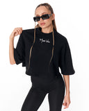 A model wearing a black cropped t-shirt with a white 'Maison Vital' logo on the chest, styled with black pants, black sunglasses, and gold chain hair accessories against a plain white background.