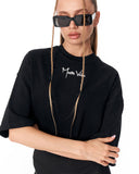 A model wearing a black oversized t-shirt with a white 'Mister Vanish' logo on the chest, styled with black sunglasses against a plain white background.