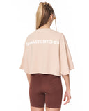 A woman modeling a cropped top in light beige and matching brown fitted shorts against a plain white background.